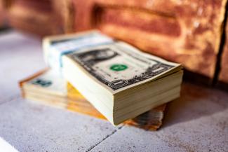 a stack of money sitting on top of a sidewalk by Marek Studzinski courtesy of Unsplash.